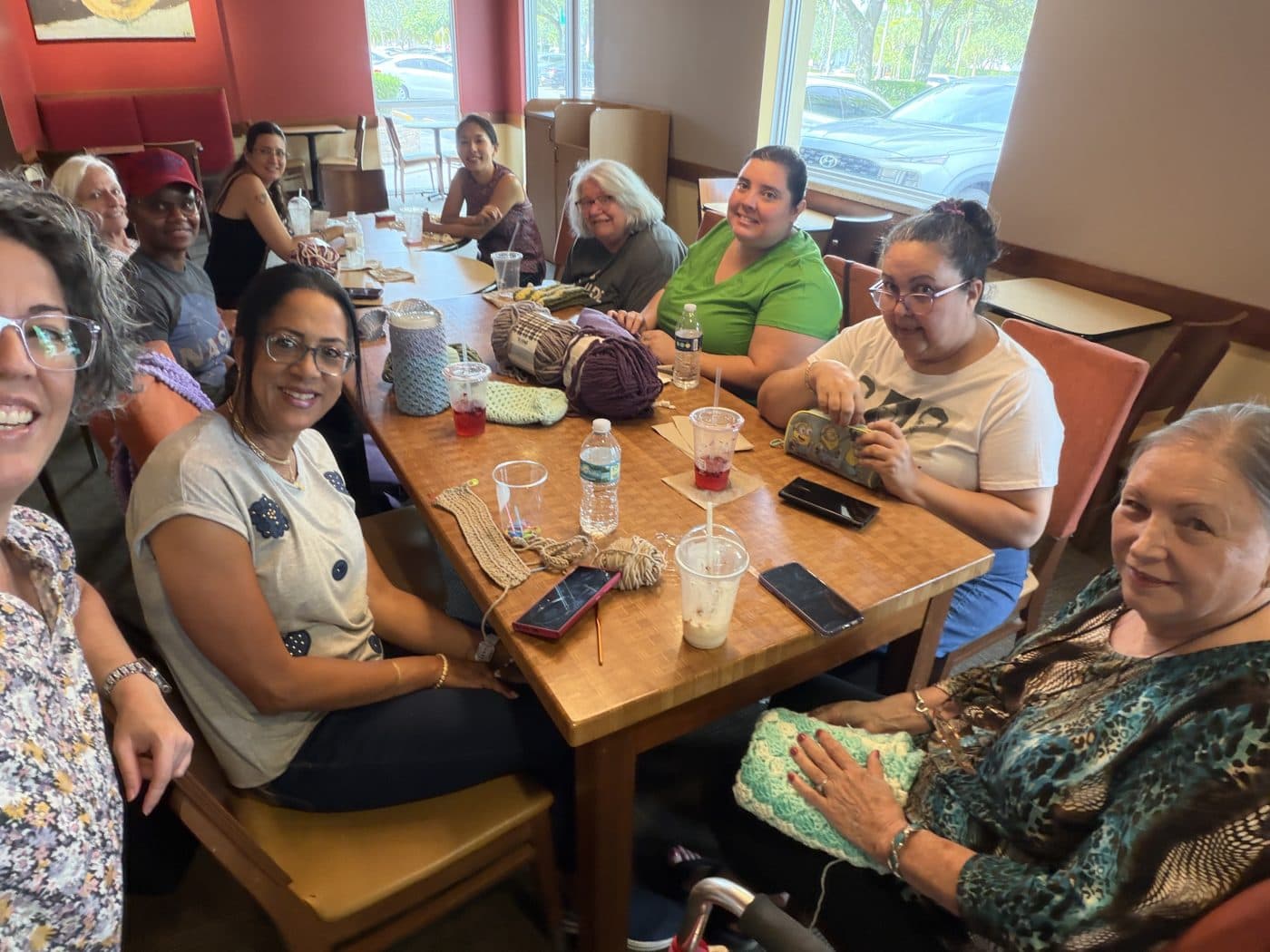 Davie Crochet Club members crocheting together around a table at a meetup