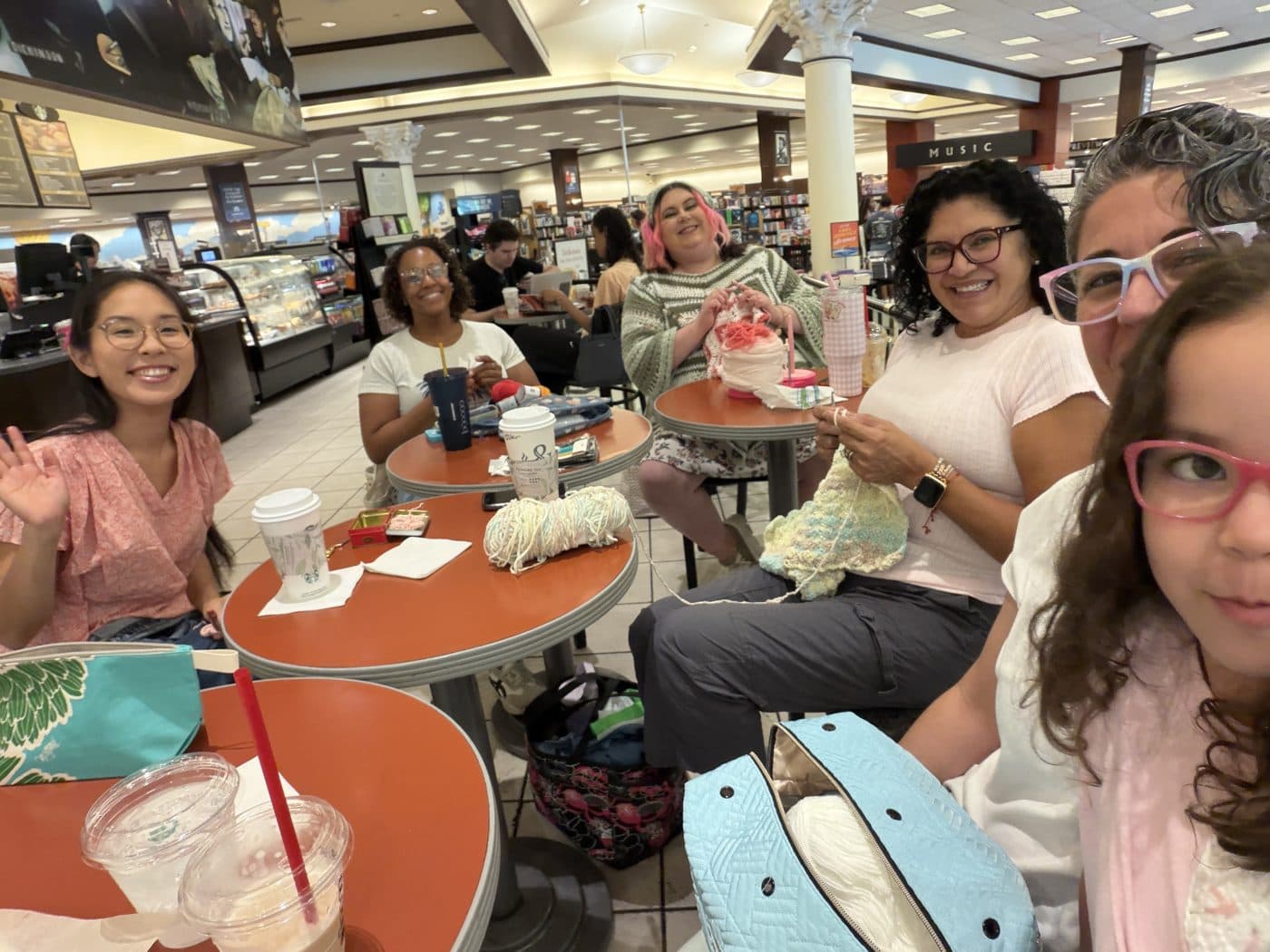 Club members smiling with their yarn and projects at a meetup